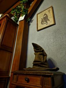 a hat sitting on top of a table next to a cabinet at Le Gîte Ensorcelé in Saint-Jean-Soleymieux