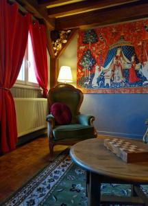 - un salon avec une chaise et une table dans l'établissement Le Gîte Ensorcelé, à Saint-Jean-Soleymieux