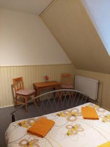 1 dormitorio con 1 cama con toallas de color naranja en Penzion Manský Dvůr, en Dolní Žandov