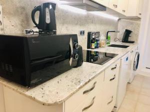 a microwave sitting on a counter in a kitchen at Ulysse, Appartement Spacieux au Centre Historique d'Uzès en rez-de-chaussée avec extérieur, proche parking des Marroniers in Uzès +21 photos