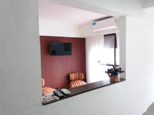 a room with two chairs and a television on a wall at Como en Casa in Rosario