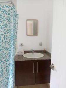 y baño con lavabo y espejo. en Excepcional apartamento cerca de todo, en Quito