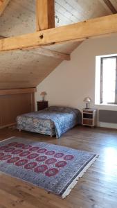 1 dormitorio con cama y alfombra en el suelo en Maison sur Rhue, en Égliseneuve-dʼEntraigues