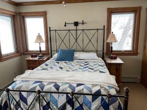 ein Schlafzimmer mit einem großen Bett und zwei Fenstern in der Unterkunft Sand Lake Getaway Lakefront in Tipton