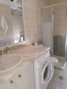 a bathroom with a sink and a washing machine at One bedroom apartment with pool in Plakias