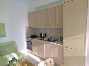 a small kitchen with white cabinets and a table at One bedroom apartment with pool in Plakias