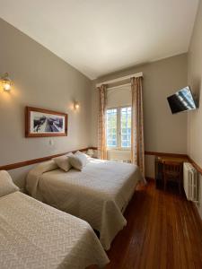 a hotel room with two beds and a window at Hotel Vicente López in Vicente López