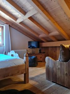 a bedroom with a bed and a flat screen tv at Le Chalet Hôtel Cordon Adults Only in Cordon