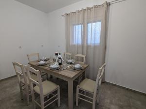 uma mesa de jantar com cadeiras e uma janela em Cute apartments em Kefalos