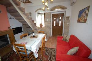a living room with a red couch and a table at Nefeli House Agios Georgios Sykousis Chios in Chios