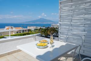 - une table blanche avec un bol de fruits sur le balcon dans l'établissement Villa Raf, à Vico Equense