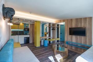 un soggiorno con divano blu e TV di Design Hotel Astra B&B a Misano Adriatico