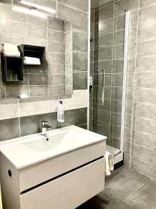 y baño con lavabo y ducha. en Hotel Lou Marquès en Saintes-Maries-de-la-Mer