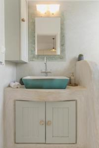 a bathroom with a blue sink and a mirror at Piperi-2 Bedroom home in Naousa