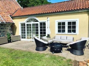 un patio trasero con una hoguera y sillas y una casa en Munkebergs gård en Kristianstad