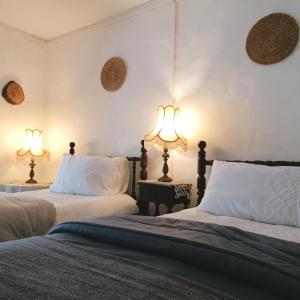 two beds in a room with two lamps at Casa do Cabeço - Termas da Sulfúrea in Cabeço de Vide
