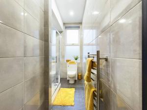 ein Bad mit einer Dusche und einem WC. in der Unterkunft Gibson Manor Apartment 10 in Wallasey