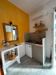 a bathroom with a sink and a mirror at Studios Matina in Naxos Chora