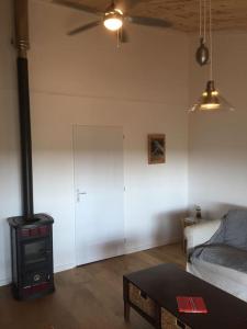 a living room with a stove and a couch at Le Gîte de l'Aérogrange in Biscarrosse