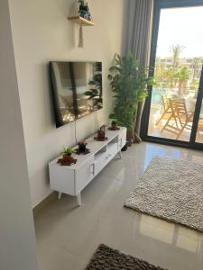 a living room with a white dresser and a mirror at Cozy studio in G cribs in Hurghada