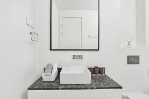 Un baño con un lavabo blanco y un espejo. en Luštica Magnolia apartment, en Tivat 27 fotos más