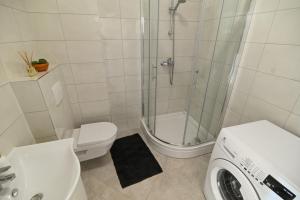 een badkamer met een douche, een toilet en een wasmachine bij Apartment Marko in Trogir
