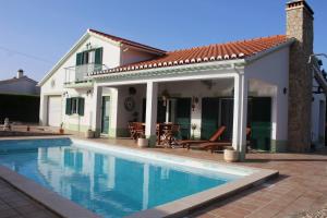 a house with a swimming pool in front of a house at Casa Delbon Guest House in Aljezur