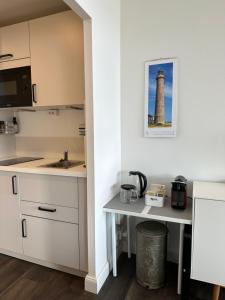 una cocina con un faro en la esquina de una habitación en Weitblick - mit Strandkorb, mehr Meer geht nicht, en Glücksburg