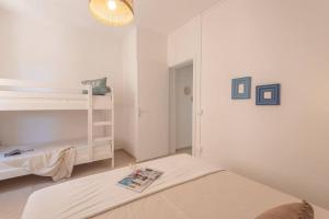 Cette chambre blanche comprend un lit et des lits superposés. dans l'établissement BILOCALE PONTICELLO SUL MARE, a 50 metri dalla spiaggia, à Rivabella