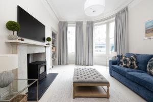 sala de estar con sofá azul y chimenea en Stylish 3-Bedroom Edinburgh City Getaway, en Edimburgo