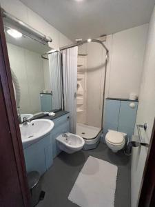 bagno con lavandino, servizi igienici e specchio di Hotel Fernanda a Rapallo