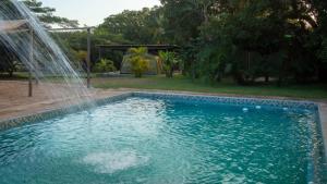 una piscina con fontana in un cortile di Lodge Umusa a KwaMazambane
