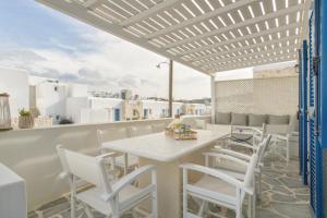 a patio with a table and chairs on a balcony at Piperi-2 Bedroom home in Naousa