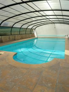 an indoor swimming pool with blue water in a building at la ferme des bigornes in Châtillon-sur-Indre