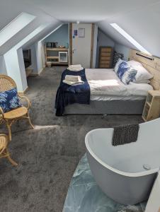 1 dormitorio con cama y bañera en Seals Bacton, en Bacton