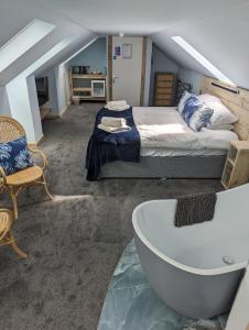 een slaapkamer met een bed en een bad bij Seals Bacton in Bacton