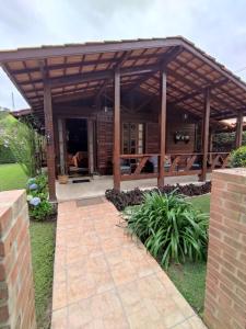 een houten paviljoen met een patio in de tuin bij Paz na Serra Teresopolis in Teresópolis