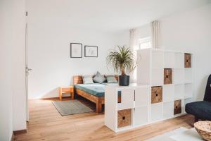 ein weißes Schlafzimmer mit einem Bett und einer Topfpflanze in der Unterkunft Haus am Zabelstein in Dingolshausen