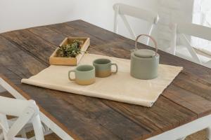 a wooden table with two coffee mugs on a napkin at Piperi-2 Bedroom home in Naousa