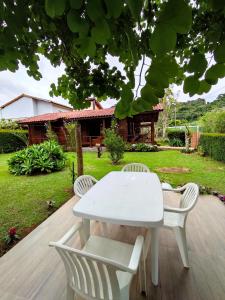 - une table blanche et 2 chaises sur la terrasse dans l'établissement Paz na Serra Teresopolis, à Teresópolis