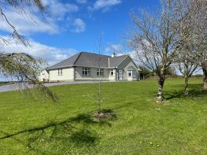 een wit huis met twee bomen in een tuin bij Ballylee in Galway