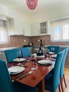 un tavolo in legno con sedie e bicchieri da vino sopra di Home Sweet Home a Archangelos