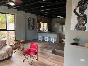 Il comprend un salon avec une chaise rouge et une cuisine. dans l'établissement Casa de campo en Panamá, à Los Altos de Cerro Azul