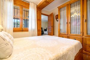 1 dormitorio con 1 cama, armarios de madera y ventanas en la casita, en Las Pesas
