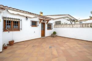 Casa blanca con patio de azulejos en la casita, en Las Pesas