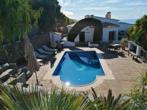 - une piscine en face d'une maison dans l'établissement La Montaña Del Oro, à Sayalonga