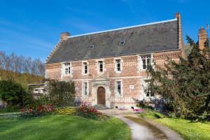 a large brick house with a garden in front of it at Auberge du Manoir d'Archelles in Arques-la-Bataille