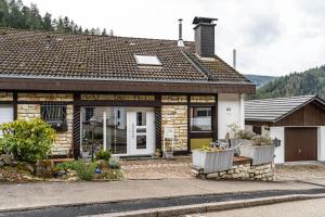 a stone house with two chairs in front of it at Ferienwohnung im Grünen in Hornberg