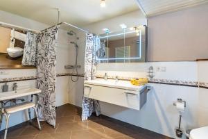 a bathroom with a sink and a shower and a mirror at Ferienwohnung im Grünen in Hornberg +24 photos