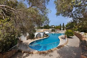 a large swimming pool with a fence around it at Apartamento Quinta do Paraíso in Carvoeiro